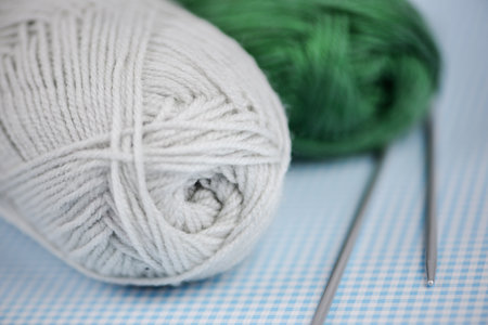 A delightful pair of colorful yarn balls accompanied by knitting needles, ideal for various crafts and DIY projectsの写真素材