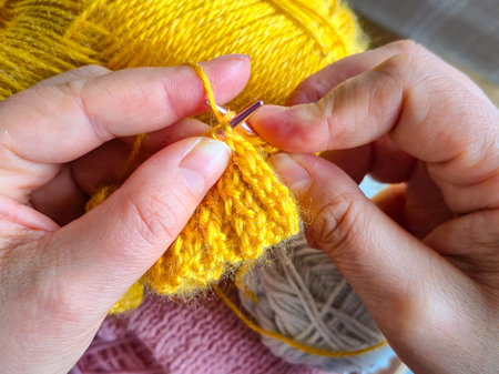 Women's hands with knitting and balls of yarn close-up, hobbies and needlework. High quality photo