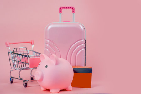 Explore vibrant travel accessories like a charming piggy bank and a colorful shopping cart against a pastel backdropの写真素材