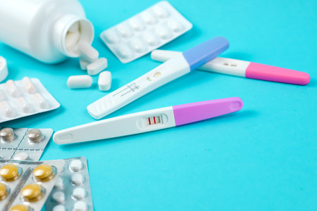 Positive pregnancy test and many medications on blue background, family planning. contraceptives....