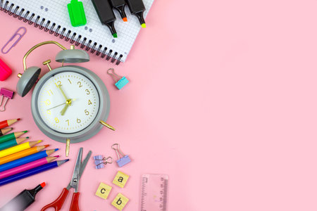 A vibrant assortment of stationery items arranged on a pink background, perfect for creative projects.の写真素材