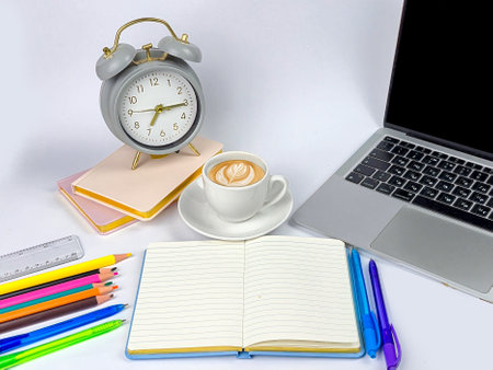 A cozy workspace with a cup of coffee, colorful stationery, and a laptop to inspire creativity and productivityの写真素材