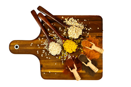 A vibrant and colorful array of spices and ingredients beautifully displayed on a wooden boardの写真素材