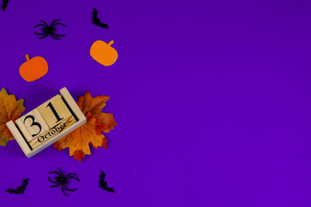 Colorful Halloween decor featuring pumpkins, spiders, and fall leaves on a vibrant purple...