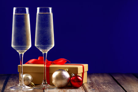 Elegant champagne glasses adorned with gifts and festive ornaments capture the essence of joyous celebrationsの写真素材