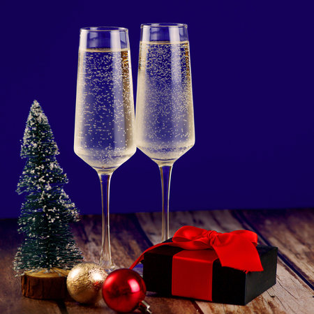 Toast with champagne, share gifts, and admire a decorated Christmas tree for a joyful heartwarming celebrationの写真素材