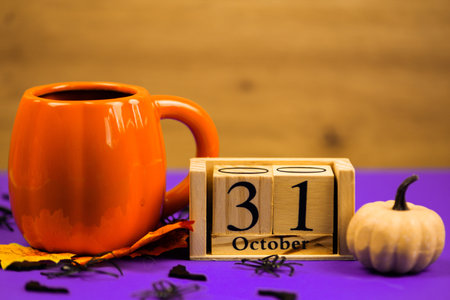 This charming autumn setup features a beautifully designed orange mug, a decorative calendar, and an adorable pumpkinの写真素材