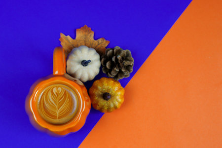 Enjoy a cozy, fallthemed coffee setup that features pumpkins, pinecones, and a vibrant, inviting backgroundの写真素材