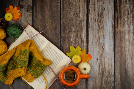 A warm and inviting indoor scene featuring a cozy book, vibrant yarn, delicious coffee, and colorful...