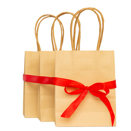 These stylish paper gift bags with a red ribbon are perfect for any occasion or thoughtful gift givingの写真素材