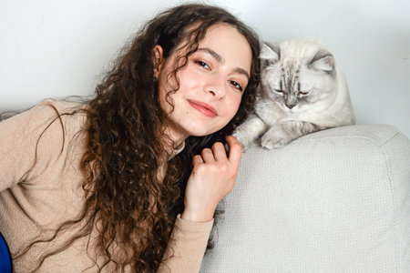 A Woman and Her Cat Are Enjoying Quality Time Together on a Cozy Couch, Embracing Comfort