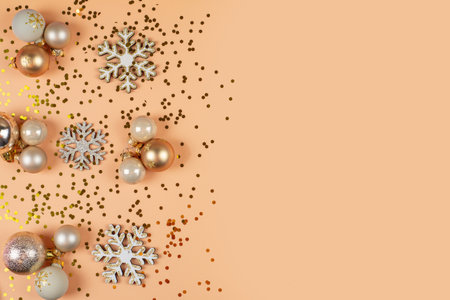 Top view vertical photo featuring variety of tree adornments, baubles, shimmering stars, snowflake accents, confetti on pastel backdrop holiday greetings or advertの写真素材