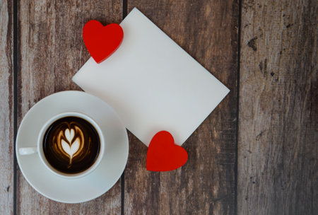 Cup of coffee with postcard and space for text on wooden background, Valentine's Day concept. High quality photoの写真素材
