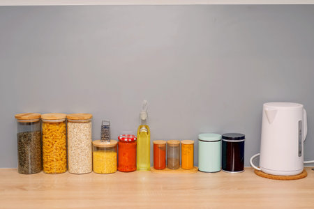 cereals and spices in glass containers on the kitchen counter