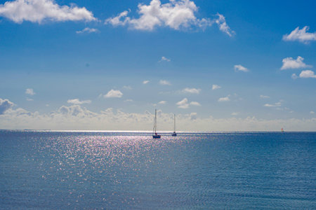 Soft Glowing Sea With Distant Yacht Under Scattered Clouds, Sparkling Reflections Across Water, Calm...