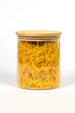 Yellow pasta, in a glass jarの写真素材