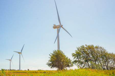 Close Turbine Towering Above Leafy Trees, Low Angle View Of Nacelle And Blades With Tree Canopy,...