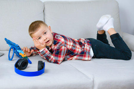 Youth Dramatizing With Devices In Cozy Setting. Child Entertainment Using Tablet And Headset During Imaginative Playの写真素材
