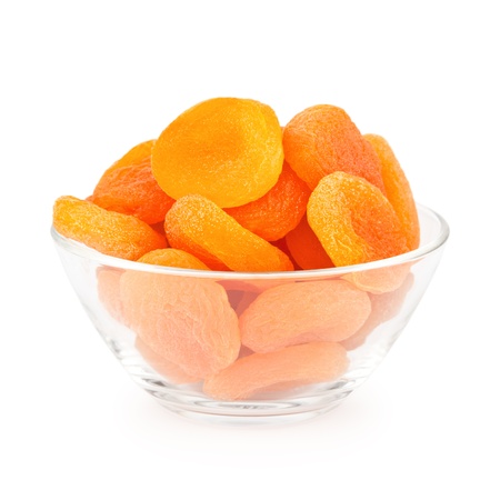Glass bowl with dried apricots isolated on white backgroundの写真素材