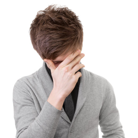 Sad young man covered his face with his hand  Isolation on white