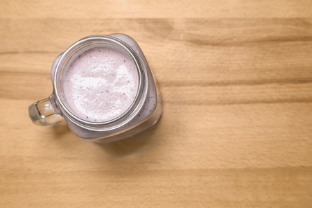 Berry smoothie in a mason jar on a wooden cutting board. Top vieの写真素材
