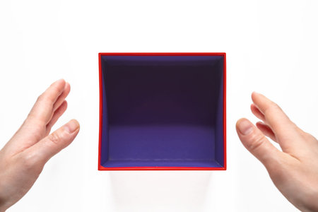 Gift or present empty box on white background with female hands top view.