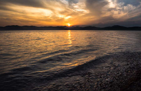 sea sunset with cloudy skyの写真素材