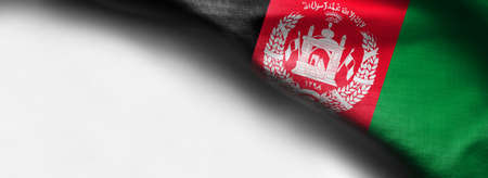 Colorful, closeup, wavy fabric flag of Afghanistan on white background - right top corner flagの写真素材