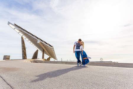 Beautiful couple hugging in the background of the sea on the coast of sea and solar stationの写真素材