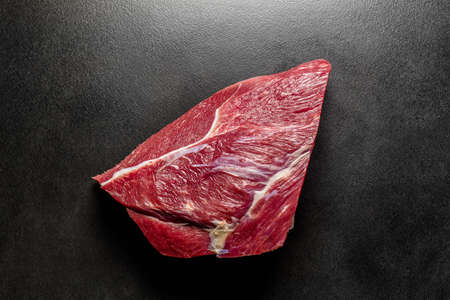 Overhead view fresh raw beef on black deck Big piece of red meat isolated on a black backgroundの写真素材