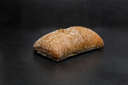 Dark homemade ciabatta buns ready to eat on black backgroundの写真素材