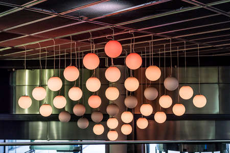 The sign of round orange lamps balls on the ceiling. The color gradient from bright to light.の写真素材