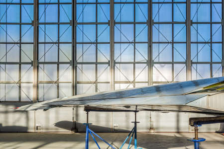 Detail of the plane stands on the blue rack in aviation hangar on the background of the windows.の写真素材