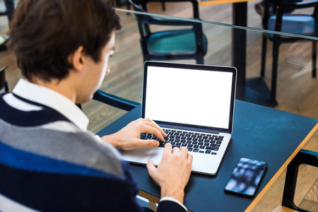 Closeup view portrait of successful business freelance man using his laptop, sitting with open...