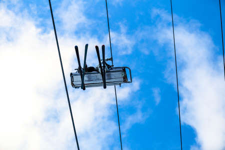 Bottom view of skiers have a fun on chair lift in the sky and steel cableの写真素材