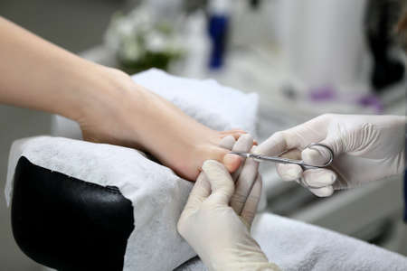 Cutting cuticle on foot, nail scissors. Pedicureの写真素材