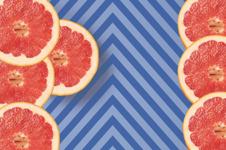Bright red grapefruit on diagonal lines texture top view. Striped background in blue and dark blue...