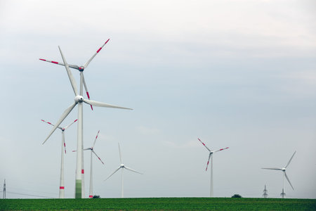 Ecological power with windmill on the field.Yard of windmill power generatorunder blue sky, shown as...