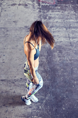 Beautiful young athletic woman in a city urban place. Fit girl with a sports figure in bright tights...