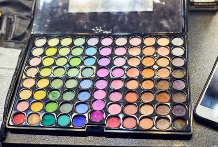 Professional multicolour eyeshadows palette, close up on black background. Beauty creative assortment of palettes with rich and deep colors of lipstick and eyeshadows.の写真素材