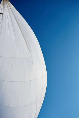 Flying the symmetric spinnaker on the yach in strong windの写真素材