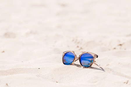 Sunglasses on sandy beach in summer - vintage color stylesの写真素材