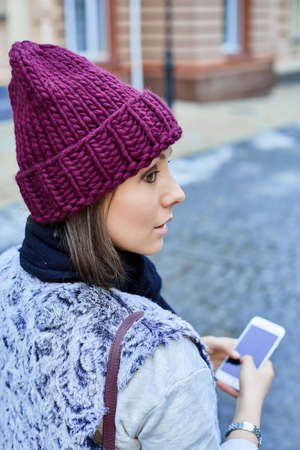 The girl with a smartphone, is walking through the old townの写真素材