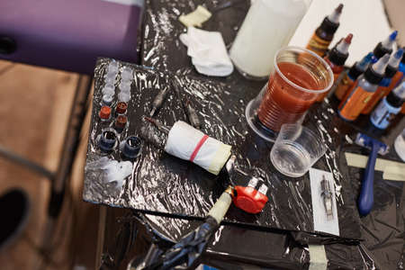 Parts of tattoo machine and bottles with colorful inks on table, close up viewの写真素材