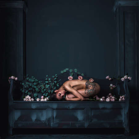 Rose in the dark. Composition of roses and beautiful body on a black background with reach green eucalyptusの写真素材