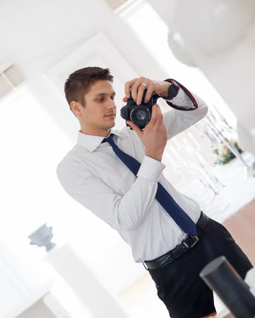 The photographer in white shirt takes a photo of himself in the mirrorの写真素材
