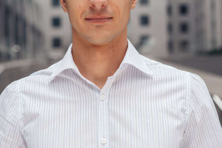 Close up of an elite shirt on a businessman. Collar of a white shirt. Part of a mans face.の写真素材