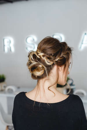 Kyiv, Ukraine - March 3, 2017: The barber makes hairstyle for bride. The model shows a beautiful hairstyle back view.のeditorial素材