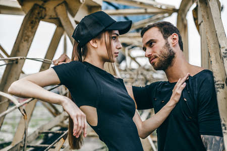 Beautiful couple in metal building structures. A man with a beard and a sexy girl in love is almost a kiss.の写真素材