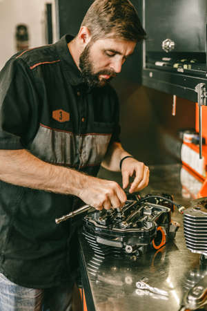 Motorcycle mechanic engine repair at service station. Motorcycle engine repair.の写真素材